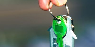 pexels photo 29094497 29094497 Close-up of a hand holding a house-shaped keychain with green keys, symbolizing home ownership.