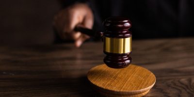 pexels photo 6077326 6077326 A gavel striking a sound block, symbolizing justice and legal authority in a courtroom setting.